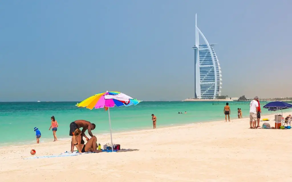 Family under a sun umbrella on a beach in Dubai