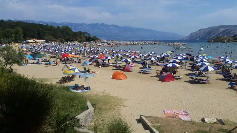 The beach has sun loungers and parasols.
